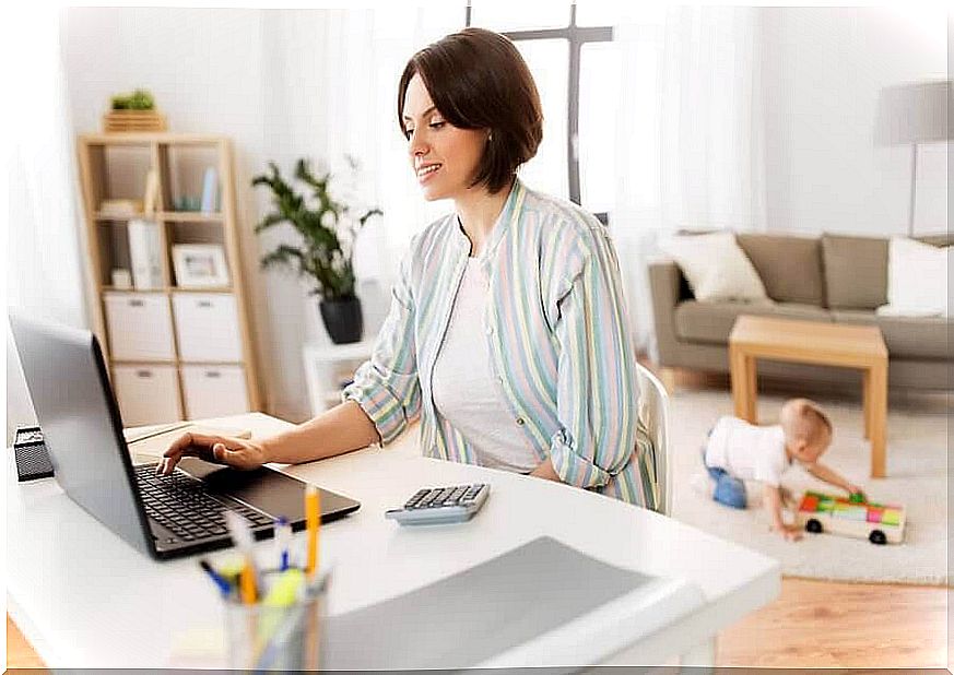 woman at computer with baby in background
