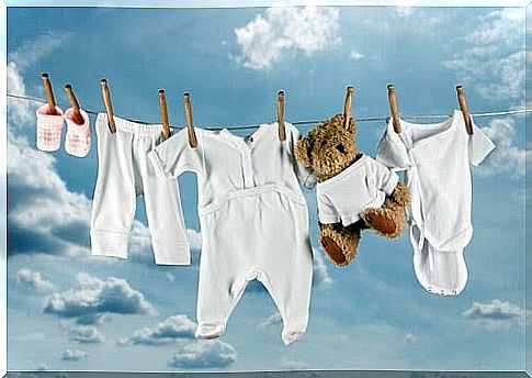 Children's clothes and a teddy bear hang on the clothesline