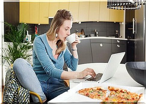mom with laptop in kitchen with pizza