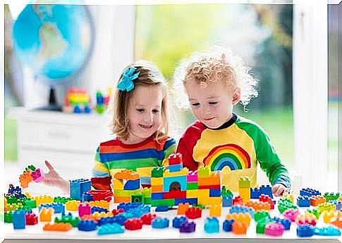 two children playing with duplo