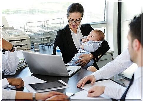 work again after maternity leave: woman with baby at computer