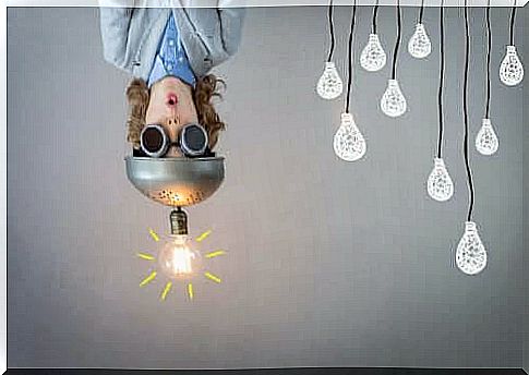 Design Thinking: child with hat with light bulb on hanging upside down