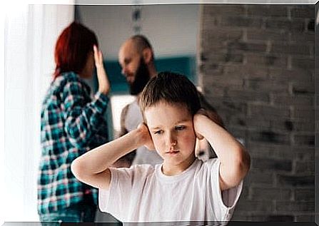 Children cover their ears while parents quarrel in the background