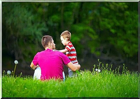 father and little boy on green meadow