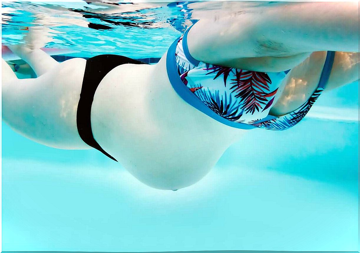 A pregnant woman swimming.