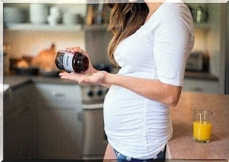 pregnant woman takes pills from a jar