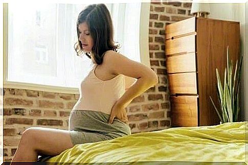 pregnant woman holding on to her back