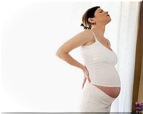 pregnant woman holding on to her back