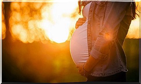 Pregnant woman holding her belly.