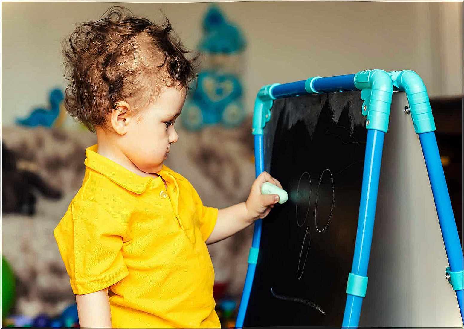 A small child draws on a board.