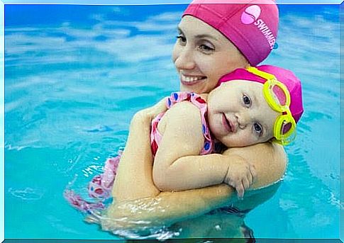Mom and baby in pool with matching pink bathing caps
