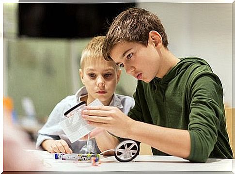 Siblings build a model car together.