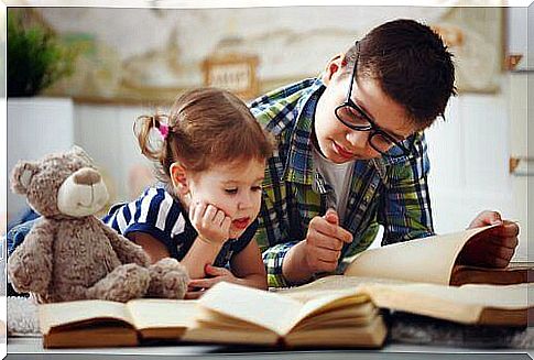 Big brother reads book to younger sister.