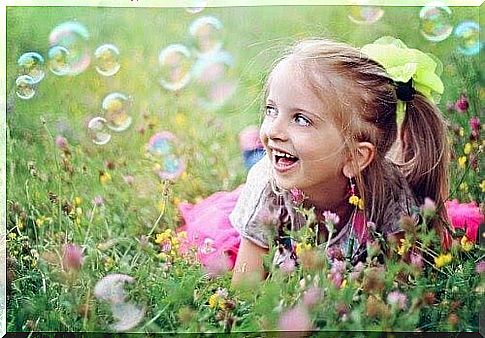 self-perception: girl on meadow with soap bubbles