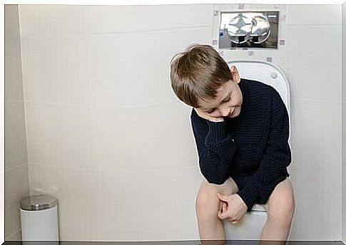 A child is sitting on the toilet trying to poop.