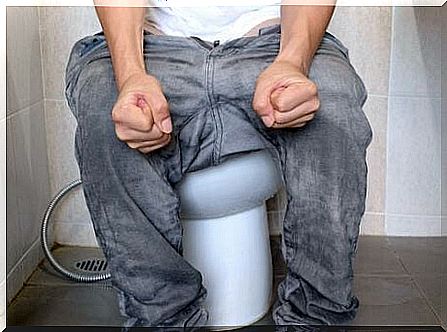 Man sitting on toilet.