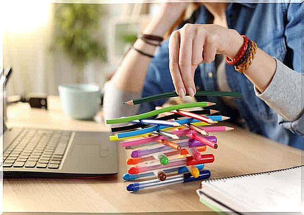 Teenager stacks pencils instead of studying.